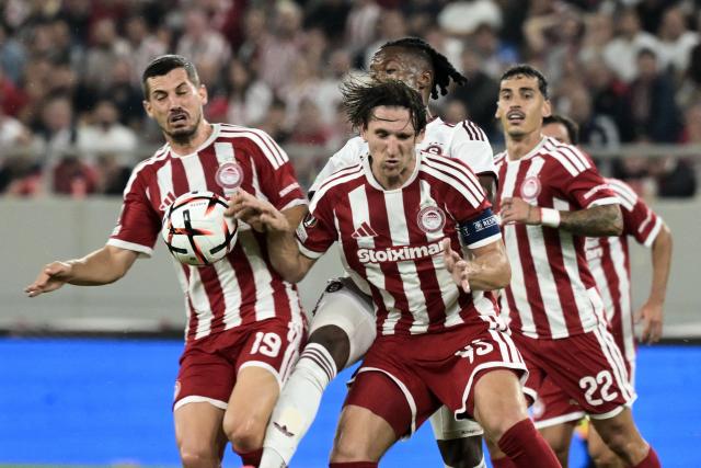 Olympiacos' defender #45 Panagiotis Retsos (R) and Olympiakos' Swiss midfielder #19 Remo Freuler (L) fights for the ball with Sparta Praha's Equatorial Guinea midfielder #05 Santiago Eneme (C) during the UEFA Europa League, league phase, matchday 3, football match between Olympiacos and Sparta Praha at Karaiskaki stadium in Athens on October 22, 2026. (Photo by Angelos TZORTZINIS / AFP)