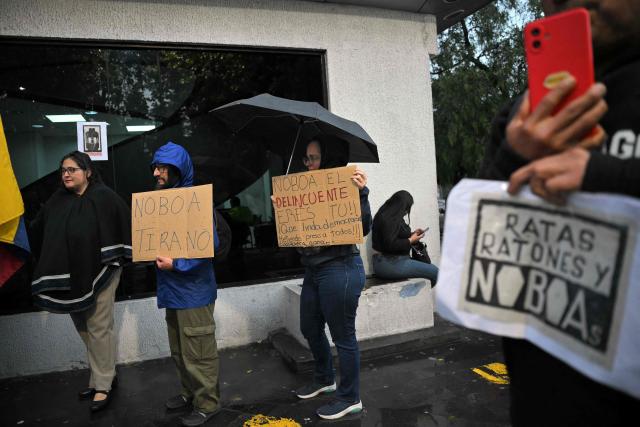 Supporters of former Ecuadorian presidential candidate Luisa Gonzalez hold signs reading "Noboa, tyrant", "Noboa, you are the criminal" and "Rats, mice and Noboa" outside the Flagrancy Unit in Quito on October 22, 2026, following her arrest. Ecuador's opposition on October 22, 2026, accused US-backed President Daniel Noboa of running a "dictatorship" following the arrest of former presidential candidate Luisa Gonzalez, the latest left-wing figure to face legal proceedings. (Photo by Rodrigo BUENDIA / AFP)