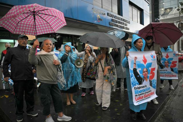 Supporters of former Ecuadorian presidential candidate Luisa Gonzalez hold posters demanding her release outside the Flagrancy Unit in Quito on October 22, 2026, following her arrest. Ecuador's opposition on October 22, 2026, accused US-backed President Daniel Noboa of running a "dictatorship" following the arrest of former presidential candidate Luisa Gonzalez, the latest left-wing figure to face legal proceedings. (Photo by Rodrigo BUENDIA / AFP)