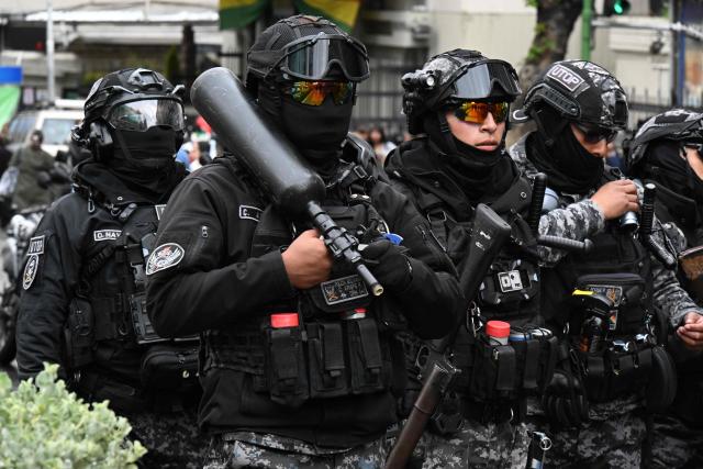 Riot police officers stand guard during a teachers' march protesting the government's economic and educational policies in La Paz on October 22, 2026. (Photo by Aizar RALDES / AFP)