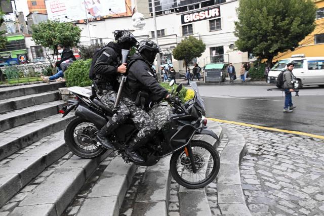 Riot police officers ride a motorcycle down a flight of steps during a teachers' march protesting the government's economic and educational policies in La Paz on October 22, 2026. (Photo by Aizar RALDES / AFP)