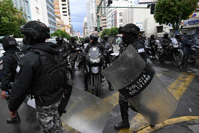 Riot police officers equipped with shields and motorcycles gather at an intersection during a teachers' march protesting the government's economic and educational policies in La Paz on October 22, 2026. (Photo by Aizar RALDES / AFP)