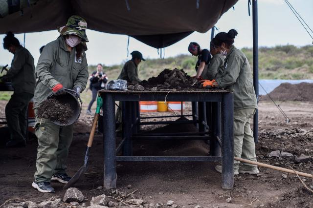 Volunteers work alongside forensic personnel from the Argentine Forensic Anthropology Team (EAAF) in the search for the human remains of people who disappeared during the last military dictatorship (1976–1983), at La Loma del Torito, on the La Calera military base on the outskirts of Cordoba, Argentina, on October 22, 2026, near the former clandestine detention, torture and extermination center known as "La Perla.".  (Photo by Cesar Heredia / AFP)