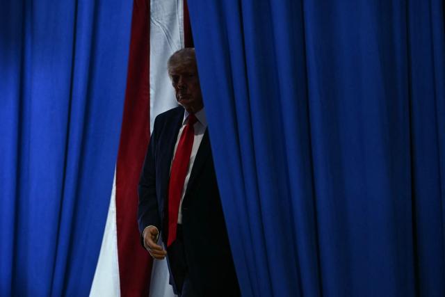 US President Donald Trump arrives to speak at a midterm election campaign rally at Sioux Gateway Airport in Sioux City, Iowa on October 22, 2026. President Trump is travelling the country to try to give a boost to Republicans in tight midterm races. (Photo by Kent NISHIMURA / AFP)