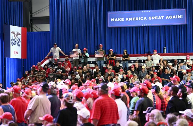 Supporters listen to US President Donald Trump speak at a midterm election campaign rally at Sioux Gateway Airport in Sioux City, Iowa on October 22, 2026. President Trump is travelling the country to try to give a boost to Republicans in tight midterm races. (Photo by Kent NISHIMURA / AFP)