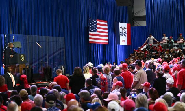 Supporters listen to US President Donald Trump speak at a midterm election campaign rally at Sioux Gateway Airport in Sioux City, Iowa on October 22, 2026. President Trump is travelling the country to try to give a boost to Republicans in tight midterm races. (Photo by Kent NISHIMURA / AFP)