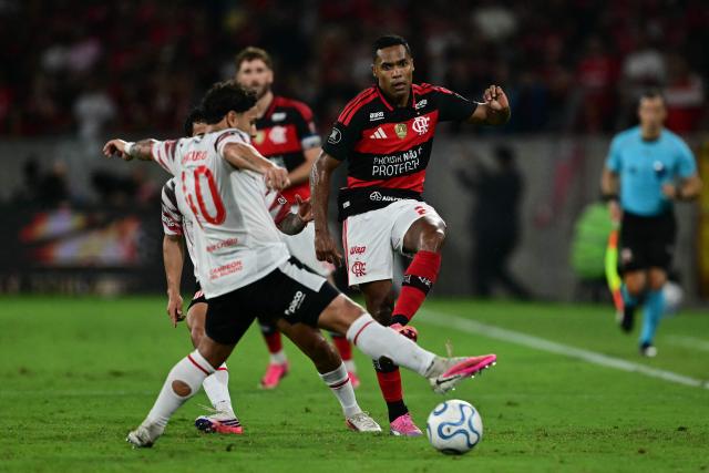 Estudiantes' defender #40 Eros Mancuso and Flamengo's defender #26 Alex Sandro fight for the ball during the Copa Libertadores semifinal second leg football match between Brazil's Flamengo and Argentina's Estudiantes de La Plata at the Maracana stadium in Rio de Janeiro, Brazil, on October 22, 2026. (Photo by Pablo PORCIUNCULA / AFP)