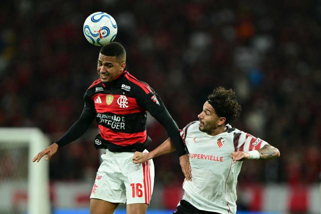 Flamengo's forward #16 Samuel Lino and Estudiantes' defender #40 Eros Mancuso fight for the ball during the Copa Libertadores semifinal second leg football match between Brazil's Flamengo and Argentina's Estudiantes de La Plata at the Maracana stadium in Rio de Janeiro, Brazil, on October 22, 2026. (Photo by Pablo PORCIUNCULA / AFP)