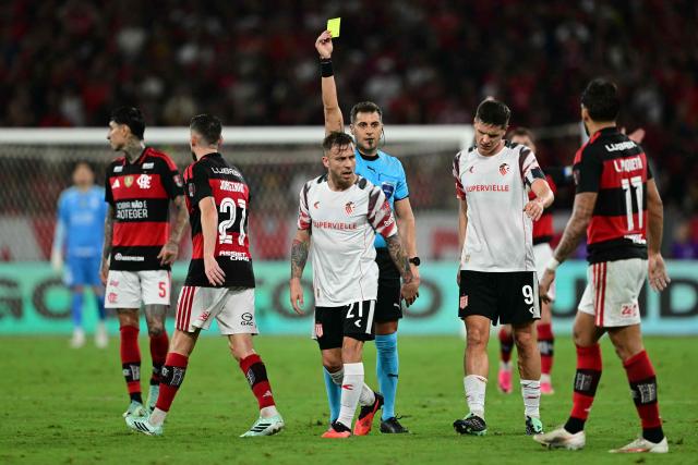 Uruguayan referee Gustavo Tejera shows a yellow card to Estudiantes' midfielder #21 Ezequiel Piovi during the Copa Libertadores semifinal second leg football match between Brazil's Flamengo and Argentina's Estudiantes de La Plata at the Maracana stadium in Rio de Janeiro, Brazil, on October 22, 2026. (Photo by Pablo PORCIUNCULA / AFP)