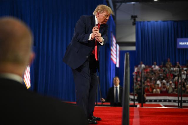 US President Donald Trump mimics a golf swing during a midterm election campaign rally at Sioux Gateway Airport in Sioux City, Iowa, on October 22, 2026. President Trump is travelling the country to try to give a boost to Republicans in tight midterm races. (Photo by Kent NISHIMURA / AFP)