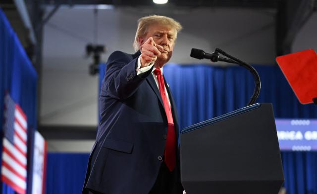 US President Donald Trump points during a midterm election campaign rally at Sioux Gateway Airport in Sioux City, Iowa on October 22, 2026. President Trump is travelling the country to try to give a boost to Republicans in tight midterm races. (Photo by Kent NISHIMURA / AFP)