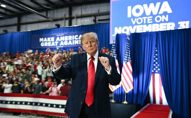 US President Donald Trump gestures during a midterm election campaign rally at Sioux Gateway Airport in Sioux City, Iowa on October 22, 2026. President Trump is travelling the country to try to give a boost to Republicans in tight midterm races. (Photo by Kent NISHIMURA / AFP)