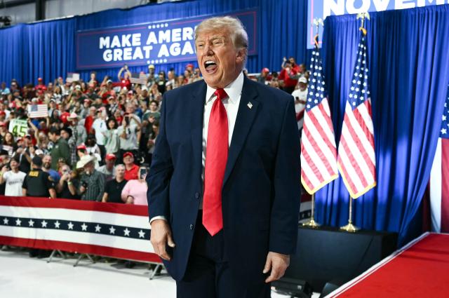 US President Donald Trump gestures during a midterm election campaign rally at Sioux Gateway Airport in Sioux City, Iowa on October 22, 2026. President Trump is travelling the country to try to give a boost to Republicans in tight midterm races. (Photo by Kent NISHIMURA / AFP)