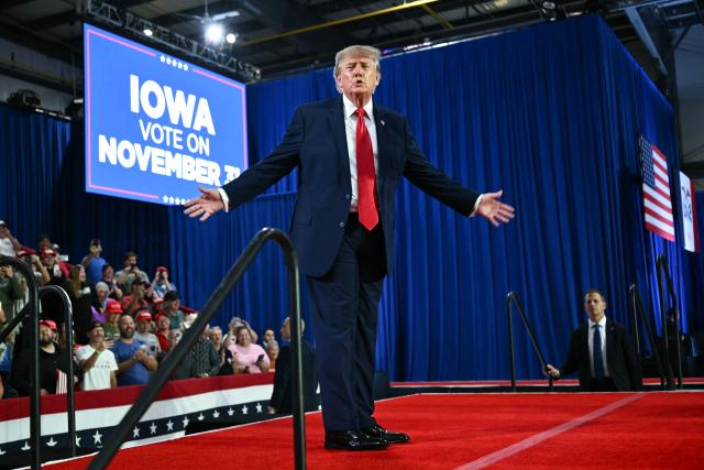 US President Donald Trump gestures during a midterm election campaign rally at Sioux Gateway Airport in Sioux City, Iowa on October 22, 2026. President Trump is travelling the country to try to give a boost to Republicans in tight midterm races. (Photo by Kent NISHIMURA / AFP)