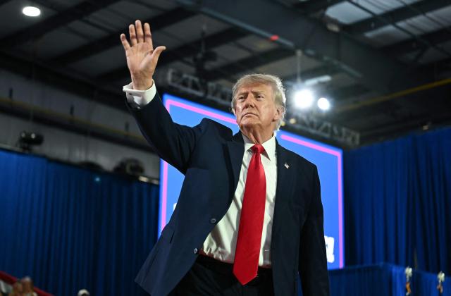 US President Donald Trump gestures during a midterm election campaign rally at Sioux Gateway Airport in Sioux City, Iowa on October 22, 2026. President Trump is travelling the country to try to give a boost to Republicans in tight midterm races. (Photo by Kent NISHIMURA / AFP)