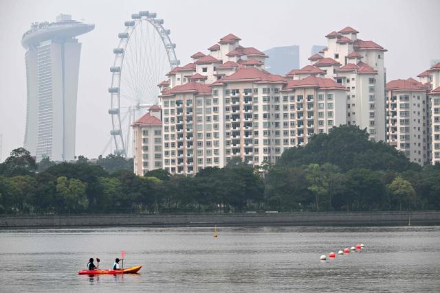 People row a canoe along the Kallang river as the haze eases in Singapore on October 23, 2026. (Photo by Roslan RAHMAN / AFP)