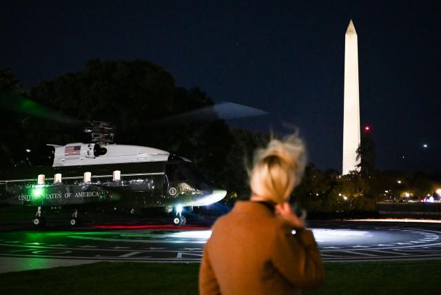 Executive assistant to the president Natalie Harp watches as Marine One carrying US President Donald Trump lands on the South Lawn of the White House in Washington, DC, early morning of October 23, 2026. President Trump is returning to Washington, DC after speaking at a midterm campaign rally in Iowa. (Photo by Alex WROBLEWSKI / AFP)