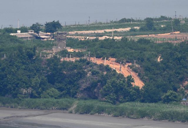 (FILES) A general view shows a North Korean guard post and military fences in North Korea's border county of Gaepung on the North Korean side of the Demilitarised Zone (DMZ), as seen from a South Korean observation deck at Aegibong Peace Ecopark in Gimpo on July 1, 2026. South Korea proposed on October 23, 2026 military talks with North Korea to "mutually confirm the precise location" of their border and discuss restoring communication channels, after an explosion in the DMZ further strained relations. (Photo by Jung Yeon-je / AFP) / To go with 'SKOREA-NKOREA-ECONOMY-CULTURE-COFFEE,FOCUS' by Kang Jin-kyu