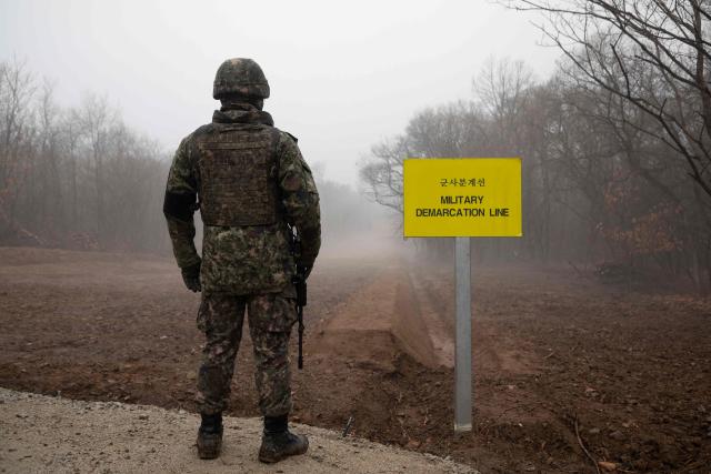 (FILES) In a photo taken on December 3, 2018 a South Korean soldier stands before the Military Demarcation Line (MDL) separating North and South Korea, on the southern side of the Demilitarized Zone (DMZ) in South Korea's Cheorwon county. South Korea proposed on October 23, 2026 military talks with North Korea to "mutually confirm the precise location" of their border and discuss restoring communication channels, after an explosion in the DMZ further strained relations. (Photo by Yelim LEE / AFP)