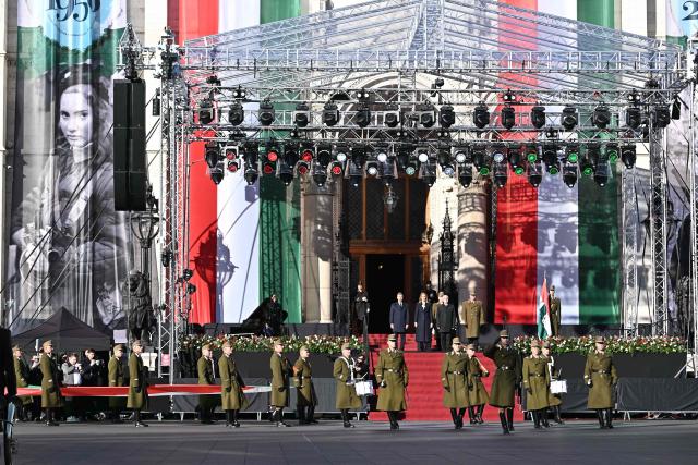 Hungarian President Andras Baka (C, 3rd L), the Speaker of the Hungarian Parliament Agnes Forsthoffer (C, 2nd L) and Hungarian Prime Minister Peter Magyar (C, L) stand in front of the parliament building in Budapest, Hungary, on October 23, 2026, during a ceremony to mark the 70th anniversary of the Hungarian Revolution of 1956, also known as the Hungarian Uprising against the Soviet communist regime. (Photo by Attila KISBENEDEK / AFP)