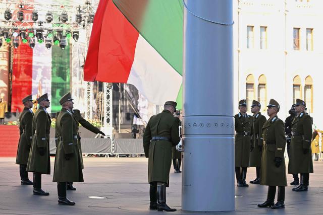 Soldiers of a Hungarian honor guard hoist their national flag at Kossuth square in front of the Hungarian Parliament building in Budapest on October 23, 2026 during a flag-hosting ceremony to mark the 70th anniversary of the Hungarian Revolution of 1956, also known as the Hungarian Uprising against the Soviet communist regime. (Photo by Attila KISBENEDEK / AFP)