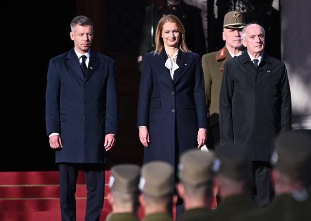 Hungarian President Andras Baka (3rd L), the Speaker of the Hungarian Parliament Agnes Forsthoffer (2nd L) and Hungarian Prime Minister Peter Magyar (L) stand in front of the parliament building in Budapest, Hungary, on October 23, 2026, during a ceremony to mark the 70th anniversary of the Hungarian Revolution of 1956, also known as the Hungarian Uprising against the Soviet communist regime. (Photo by Attila KISBENEDEK / AFP)