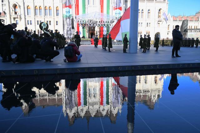The Hungarian parliament reflects in a water surface at Kossuth square in front of the Hungarian Parliament building in Budapest on October 23, 2026 during a flag-hosting ceremony to mark the 70th anniversary of the Hungarian Revolution of 1956, also known as the Hungarian Uprising against the Soviet communist regime. (Photo by Attila KISBENEDEK / AFP)