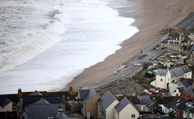 Waves break against the shoreline on Chesil Beach in Weymouth, southern England on October 23, 2026, as as Storm Austen brought strong winds and heavy rain across much of southern England. (Photo by Henry NICHOLLS / AFP)