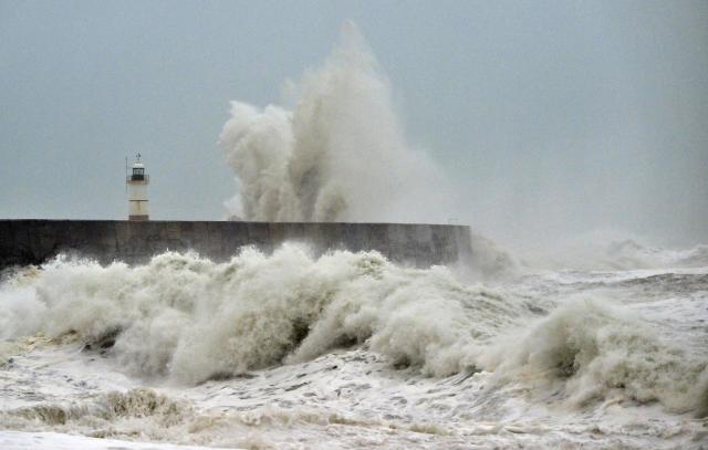 Waves crash over Newhaven Lighthouse and the breakwater in Newhaven, southern England on October 23, 2026, as as Storm Austen brought strong winds and heavy rain across much of southern England. Storm Auste (Photo by GLYN KIRK / AFP)