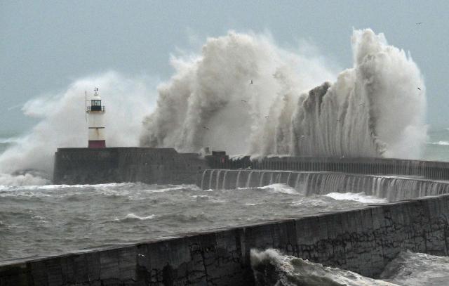 Waves crash over Newhaven Lighthouse and the breakwater in Newhaven, southern England on October 23, 2026, as as Storm Austen brought strong winds and heavy rain across much of southern England. Storm Auste (Photo by GLYN KIRK / AFP)