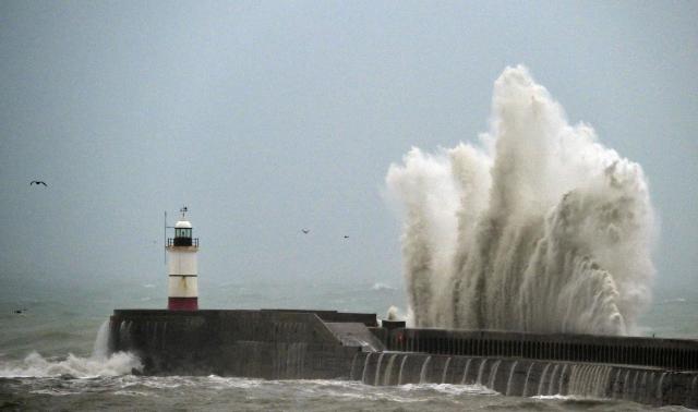 Waves crash over Newhaven Lighthouse and the breakwater in Newhaven, southern England on October 23, 2026, as as Storm Austen brought strong winds and heavy rain across much of southern England. Storm Auste (Photo by GLYN KIRK / AFP)