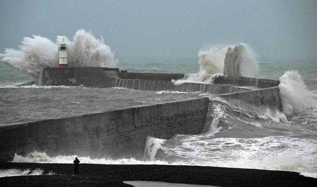 Waves crash over Newhaven Lighthouse and the breakwater in Newhaven, southern England on October 23, 2026, as as Storm Austen brought strong winds and heavy rain across much of southern England. Storm Auste (Photo by GLYN KIRK / AFP)