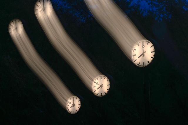 A long-exposure photograph shows clocks of the art installation 'Zeitfeld' (time field) by German artist Klaus Rinke in Duesseldorf, western Germany, on October 23, 2026. Daylight Saving Time will end on October 25, 2026, and clocks will be turned one hour backward for winter time. (Photo by Ina FASSBENDER / AFP)