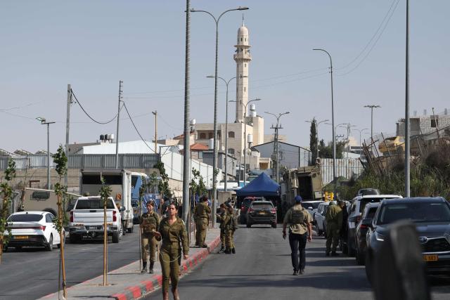 Israeli soldiers gather at the scene of an earlier fire exchange between armed Palestinians and Israeli forces following an incident at the norther checkpoint of Hebron in the Israeli-occupied West Bank on October 23, 2026. Israeli troops on October 23 shot dead two suspected Palestinian assailants in the West Bank after a shooting that left at least five people wounded, officials said. (Photo by Ahmad GHARABLI / AFP)