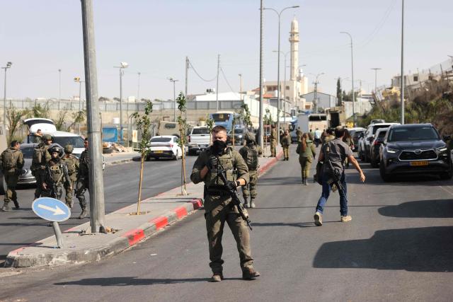 Israeli soldiers gather at the scene of an earlier fire exchange between armed Palestinians and Israeli forces following an incident at the norther checkpoint of Hebron in the Israeli-occupied West Bank on October 23, 2026. Israeli troops on October 23 shot dead two suspected Palestinian assailants in the West Bank after a shooting that left at least five people wounded, officials said. (Photo by AHMAD GHARABLI / AFP)