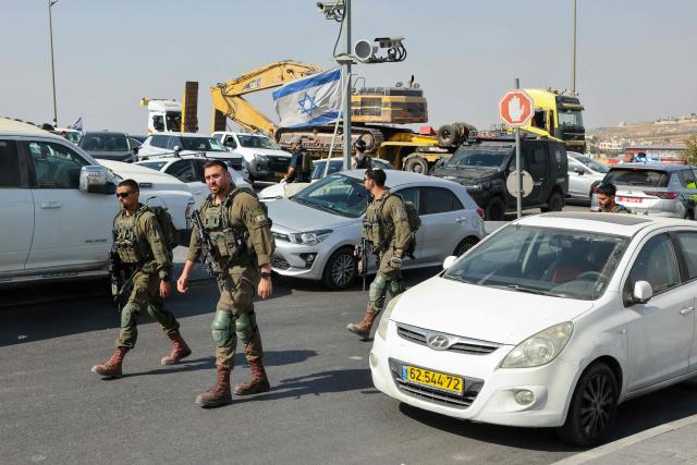 Israeli soldiers gather at the scene of an earlier fire exchange between armed Palestinians and Israeli forces following an incident at the norther checkpoint of Hebron in the Israeli-occupied West Bank on October 23, 2026. Israeli troops on October 23 shot dead two suspected Palestinian assailants in the West Bank after a shooting that left at least five people wounded, officials said. (Photo by AHMAD GHARABLI / AFP)