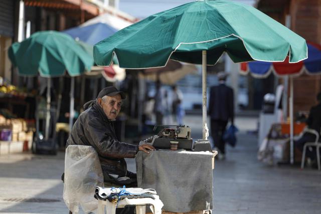 A man offering public typing and writing services uses a traditional typewriter at Bab El Had Square in Rabat, near the entrance to the medina on October 23, 2023. Street typewriting persists in Rabat as public writers provide customers with bureaucratic drafting and formatting of administrative documents. (Photo by Abdel Majid BZIOUAT / AFP)