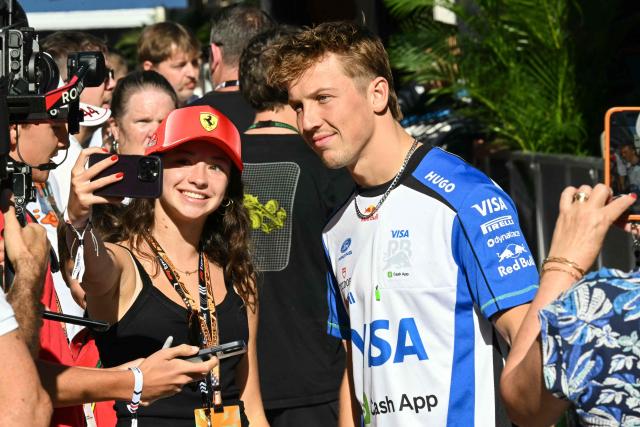 Racing Bulls' New Zealand driver Liam Lawson poses for a photo with a fan ahead of the practice session for the United States Formula One Grand Prix at the Circuit of the Americas in Austin, Texas, on October 23, 2026. (Photo by RONALDO SCHEMIDT / AFP)