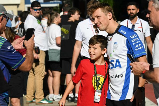 Racing Bulls' New Zealand driver Liam Lawson poses for a photo with a fan ahead of the practice session for the United States Formula One Grand Prix at the Circuit of the Americas in Austin, Texas, on October 23, 2026. (Photo by RONALDO SCHEMIDT / AFP)