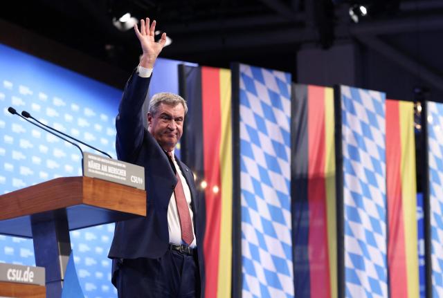Bavaria's State Premier and leader of the conservative Christian Social Union (CSU) Markus Soeder (R) waves after delivering a speech during the Christian Social Union (CSU) party congress in Munich, on October 23, 2026. (Photo by Alexandra BEIER / AFP)
