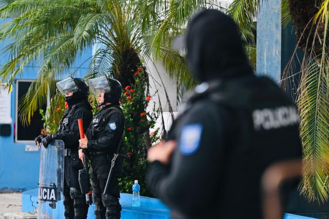 National Police officers stand guard outside the Modelo Police Headquarters, where former presidential candidate Luisa Gonzalez is being held, in Guayaquil, Ecuador, on October 23, 2026. Ecuadorian police arrested former left-wing presidential candidate Luisa Gonzalez on October 22, 2026, over alleged money laundering during the 2023 election campaign that brought current President Daniel Noboa to power. (Photo by MARCOS PIN / AFP)