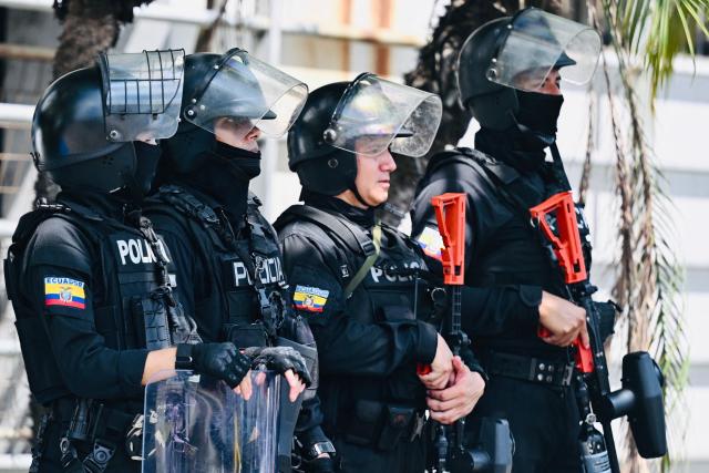 National Police officers stand guard outside the Modelo Police Headquarters, where former presidential candidate Luisa Gonzalez is being held, in Guayaquil, Ecuador, on October 23, 2026. Ecuadorian police arrested former left-wing presidential candidate Luisa Gonzalez on October 22, 2026, over alleged money laundering during the 2023 election campaign that brought current President Daniel Noboa to power. (Photo by MARCOS PIN / AFP)
