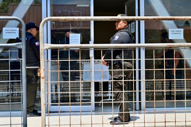 National Police officers stand guard outside the Modelo Police Headquarters, where former presidential candidate Luisa Gonzalez is being held, in Guayaquil, Ecuador, on October 23, 2026. Ecuadorian police arrested former left-wing presidential candidate Luisa Gonzalez on October 22, 2026, over alleged money laundering during the 2023 election campaign that brought current President Daniel Noboa to power. (Photo by MARCOS PIN / AFP)