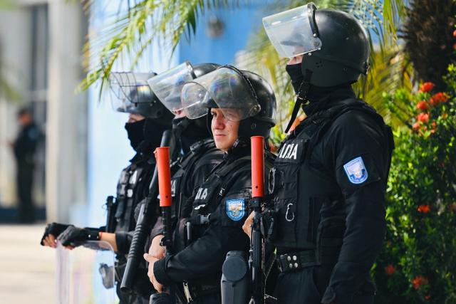 National Police officers stand guard outside the Modelo Police Headquarters, where former presidential candidate Luisa Gonzalez is being held, in Guayaquil, Ecuador, on October 23, 2026. Ecuadorian police arrested former left-wing presidential candidate Luisa Gonzalez on October 22, 2026, over alleged money laundering during the 2023 election campaign that brought current President Daniel Noboa to power. (Photo by MARCOS PIN / AFP)