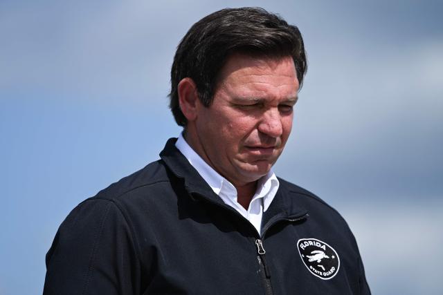 Governor of Florida Ron DeSantis waits in front of the Presidential limousine known as 'The Beast' as US President Donald Trump steps off Air Force One upon arrival at Southwest Florida International Airport in Fort Myers, Florida on October 23, 2026. President Trump is travelling to Florida to speak at a midterm campaign rally. (Photo by Brendan SMIALOWSKI / AFP)