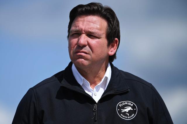 Governor of Florida Ron DeSantis waits as US President Donald Trump steps off Air Force One upon arrival at Southwest Florida International Airport in Fort Myers, Florida on October 23, 2026. President Trump is travelling to Florida to speak at a midterm campaign rally. (Photo by Brendan SMIALOWSKI / AFP)
