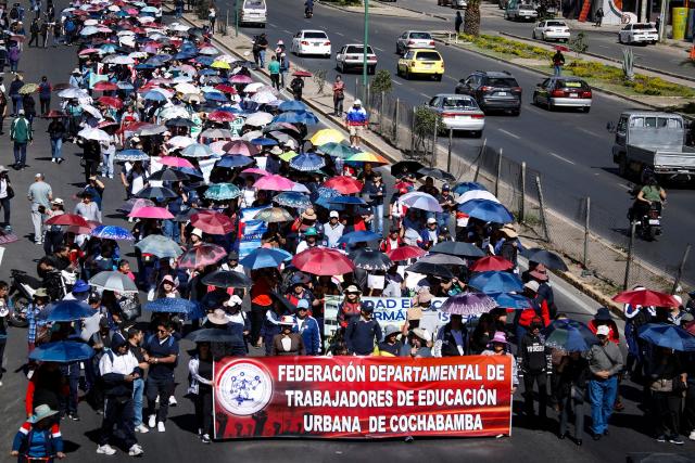 Public school teachers take part in a protest march through the streets of Cochabamba, Bolivia, on October 23, 2026. Hundreds of teachers marched in several Bolivian cities to demand salary increases amid the country's severe economic crisis and to oppose a proposed public education reform put forward by the government. (Photo by David FLORES / AFP)