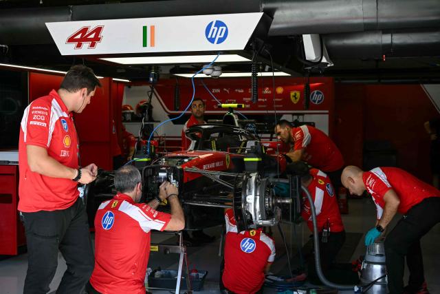 Ferrari technicians work on the car of Ferrari's British driver Lewis Hamilton in the garage before the second practice session for the United States Formula One Grand Prix at the Circuit of the Americas in Austin, Texas, on October 23, 2026. (Photo by RONALDO SCHEMIDT / AFP)