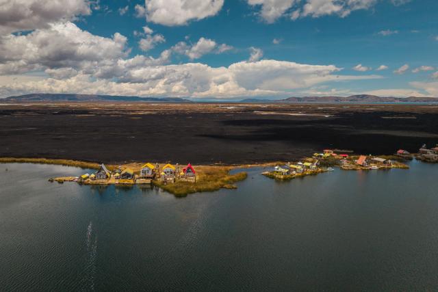 This aerial view shows a huge blackened area in the Lake Titicaca National Reserve near the floating islands of the Uros in Puno, Peru, on October 23, 2026, following a fire that ravaged around 400 hectares of totora reeds on October 21. Forest fires fueled by El Nino have killed 12 people and left hundreds homeless in Peru since June, authorities in the Andean country said on October 21. (Photo by URIEL MONTEFUR / AFP)
