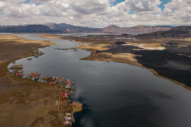 This aerial view shows a huge blackened area in the Lake Titicaca National Reserve near the floating islands of the Uros in Puno, Peru, on October 23, 2026, following a fire that ravaged around 400 hectares of totora reeds on October 21. Forest fires fueled by El Nino have killed 12 people and left hundreds homeless in Peru since June, authorities in the Andean country said on October 21. (Photo by URIEL MONTEFUR / AFP)